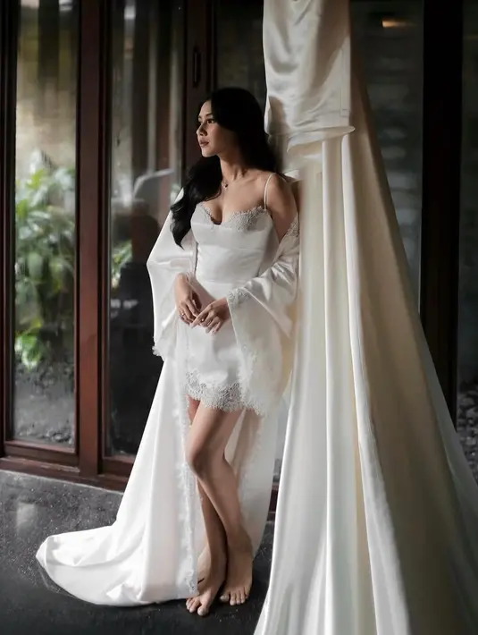 Inner dress dengan spaghetti strap memperlihatkan neckline berbentuk sweetheart yang dihiasi lace, menciptakan kesan romantis. Sementara itu, detail renda di bagian bawah rok menambah sentuhan feminin tanpa berlebihan.  [@hiantjen].