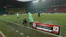 Petugas membuat lubang resapan untuk menguras air yang menggenangi lapangan di Stadion Patriot, Bekasi, Senin (13/11/2017). Drainase yang buruk menyebabkan lapangan terendam air. (Bola.com/M Iqbal Ichsan)