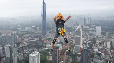 Seorang pelompat BASE terjun dari Menara Kuala Lumpur selama KL Tower International Jump Malaysia di Kuala Lumpur, Jumat (3/2/2023). Event wisata olahraga ini mengajak traveler penantang adrenalin untuk base jump, semacam terjun bebas, dari sisi atas menara di ketinggian sekitar 300 meter. (AP Photo/Vincent Thian)