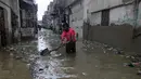 Seorang pria membersihkan jalan yang banjir setelah hujan deras, di Karachi, Pakistan, Selasa (30/7/2019). Departemen Meteorologi Pakistan mengatakan bahwa hujan memasuki provinsi Sindh dari Rajasthan India dan memperkirakan hujan akan turun tiga hari lagi. (AP Photo/Fareed Khan)