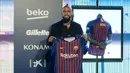 Pemain baru Barcelona, Arturo Vidal menunjukkan jersey Barcelona dalam presentasi resminya di Stadion Camp Nou, Barcelona, Spanyol, Senin (6/8). (Josep LAGO/AFP)