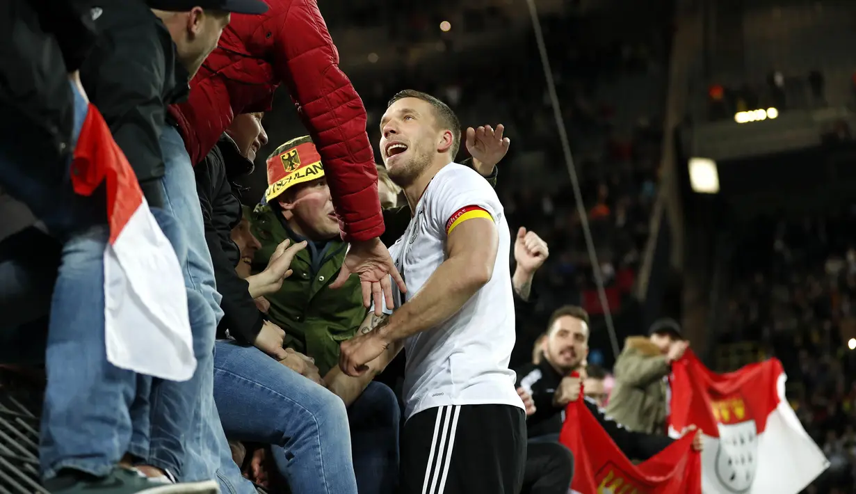 Gelandang Jerman, Lukas Podolski, menghampiri suporter usai mencetak gol ke gawang Inggris. Podolski mampu tampil sebagai bintang di laga terakhirnya berseragam timnas Jerman. (EPA/Friedemann Vogel)