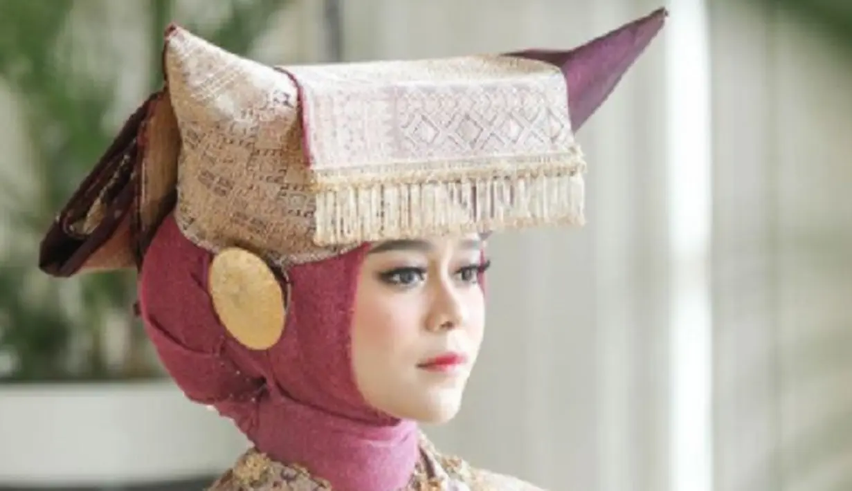 Penutup kepala yang dikenakan Lesti Kejora di Malam Bainai adalah jenis Tingkuluak Tanduak, karena bentuknya menyerupai tanduk kerbau. Nuansa senada, yaitu ungu dan emas juga digunakan pada Tingkuluak Tanduak yang digunakan Lesti Kejora. Foto: Instagram @aldiphoto.