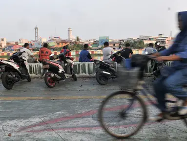 Warga memarkirkan sepeda motor di trotoar Danau Sunter, Jakarta, Senin (22/7/2019). Tidak adanya fasilitas parkir di kawasan tersebut menyebabkan pengunjung Danau Sunter memarkirkan sepeda motor mereka di sepanjang trotoar sehingga mengganggu akses pejalan kaki. (merdeka.com/Iqbal Nugroho)