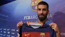 Pemain baru Barcelona, Arda Turan berpose dengan jersey Barcelona saat diperkenalkan secara resmi di Camp Nou Stadium, Barcelona (10/7/2015). Arda Turan didatangkan Barcelona dari Atletico Madrid pada awal musim 2015/2016 dengan nilai transfer sebesar 34 juta euro atau kini setara Rp547 miliar. Bertahan hingga tengah musim 2017/2018 ia total tampil dalam 55 laga di semua ajang dengan torehan 15 gol dan 11 assist. (AFP/Lluis Gene)