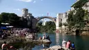 Para penonton menyaksikan aksi peserta pria melompat dari jembatan saat mengkuti acara kompetisi menyelam tradisional 450 di Mostar, Bosnia dan Herzegovina, (31/7). (REUTERS/Dado Ruvic)