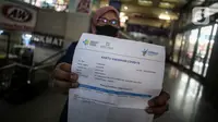 Warga menunjukan kartu vaksin di Pasar Tanah Abang, Jakarta, Selasa (27/7/2021). Pasar Tanah Abang yang kembali dibuka mulai Senin (26/7) mewajibkan pengunjung serta pedagang menunjukkan sertifikat vaksinasi COVID-19 untuk masuk ke pasar. (Liputan6.com/Johan Tallo)