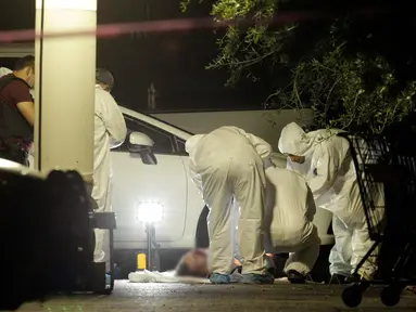  Tim forensik memeriksa tubuh seorang detektif polisi yang ditembak mati oleh penyerang tak dikenal di sebuah tempat parkir di San Pedro Garza, Monterrey, Meksiko, 9 Mei 2016. (REUTERS / Daniel Becerril)