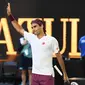 Petenis Swiss, Roger Federer merayakan kemenangannya atas Tennys Sandgren dari Amerika Serikat pada babak perempat final tunggal putra Australia Terbuka di Melbourne, Selasa (28/1/2020). Federer melaju ke semifinal usai mengalahkan Sandgren. (Manan VATSYAYANA/AFP)