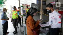 Petugas membantu calon penumpang memindai kode batang (QR Code) melalui aplikasi PeduliLindungi sebelum menaiki KRL di Stasiun Manggarai, Jakarta, Selasa (7/9/2021). PT KAI Commuter melakukan uji coba penggunaan aplikasi PeduliLindungi bagi pengguna KRL di 11 stasiun. (Liputan6.com/Faizal Fanani)