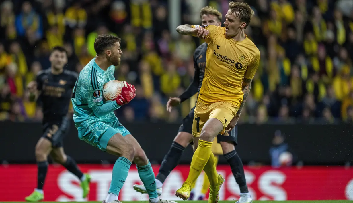Kiper Arsenal Matt Turner berebut bola dengan penyerang Bodo/Glimt Runar Espejord pada pekan ke-4 Grup A Liga Europa 2022/2023 di Aspymra Stadion, Norwegia, Kamis malam (13/10/2022). Gol semata wayang Arsenal dicetak Bukayo Saka. (Fredrik Varfjell/NTB Scanpix via AP)