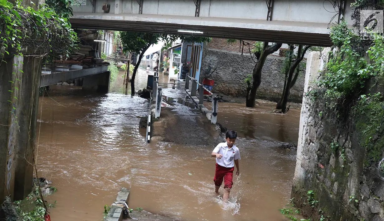 Seorang anak melintasi banjir yang menggenangi kawasan Cilandak Timur, Jakarta Selatan, Selasa (22/1). Hujan deras yang mengguyur Jakarta dan sekitarnya sejak pagi menyebabkan banjir di sejumlah sudut Ibu Kota. (Liputan6.com/Immanuel Antonius)