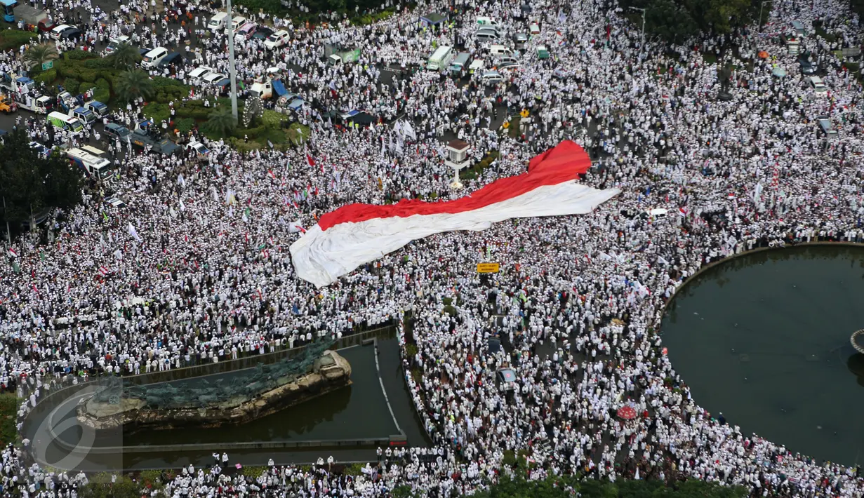 Sebuah bendera merah putih berukuran besar dibentangkan saat aksi damai di Bundaran Patung Kuda, Jakarta, Jumat (4/11). Massa menuntut  Gubernur Jakarta Basuki T Purnama agar diadili  atas dugaan penistaan agama. (Liputan6.com/Fery Pradolo)