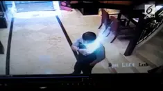 Sebuah ponsel tiba-tiba meledak saat berada di saku seorang pria. Kejadian ini terekam kamera pengintai di dalam gedung.