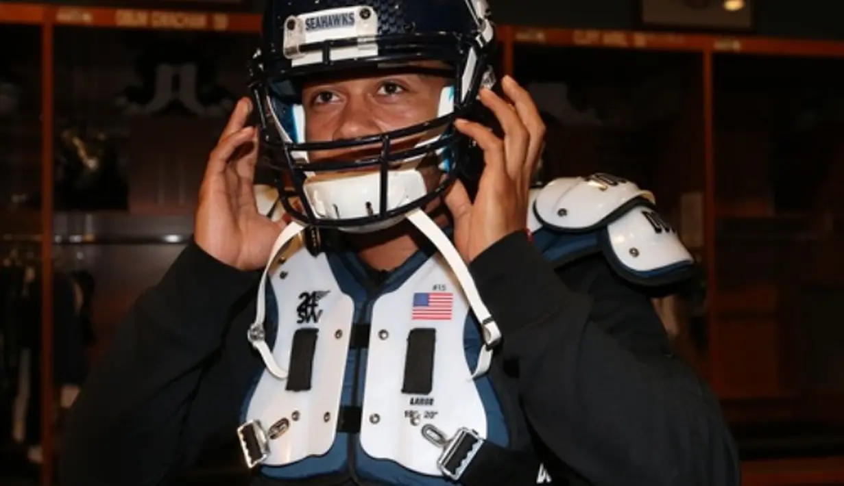 Memphis Depay mencoba perlengkapan American Football. (Manutd.com)