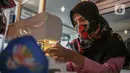 Perajin menyelesaikan pembuatan masker batik di Butik Elemwe, Jakarta, Jumat (2/10/2020). Badan Standardisasi Nasional (BSN) mengeluarkan spesifikasi masker kain ber-SNI yang terbagi menjadi tiga tipe berdasarkan penggunaannya. (Liputan6.com/Faizal Fanani)