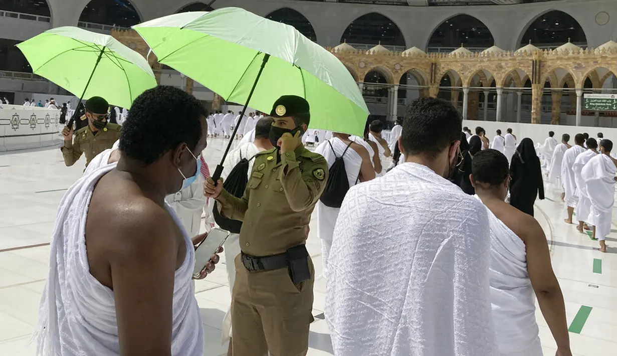 Polisi mengawasi umat muslim untuk memastikan jaga jarak sosial untuk membantu menghentikan penyebaran virus corona COVID-19 saat pelaksanaan umrah di Masjidil Haram, Makkah, Arab Saudi, Minggu (30/5/2021). (AP Photo/Amr Nabil)