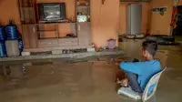 Nonton televisi di tengah kepungan banjir (Liputan6.com/M Syukur)