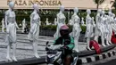 Pengendara melintasi puluhan boneka maneken yang dipajang di Bundaran HI, Jakarta, Minggu (15/11/2020). Boneka maneken tersebut sebagai bentuk "Mengenang Korban Kecelakaan Lalu Lintas 2020" serta kampanye agar masyarakat lebih berhati -hati dan tertib berlalu lintas. (Liputan6.com/Johan Tallo)