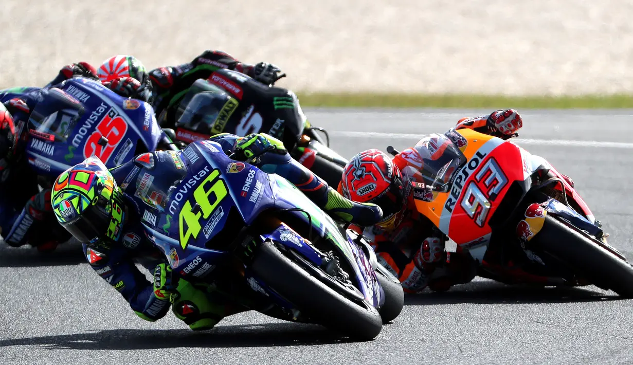 Pembalap Repsol Honda, Marc Marquez (kedua) berduel dengan pembalap Yamaha Valentino Rossi (depan) memperebutkan posisi pertama saat MotoGP Australia di Phillip Island (22/10). (AFP Photo/Glenn Nicholls)
