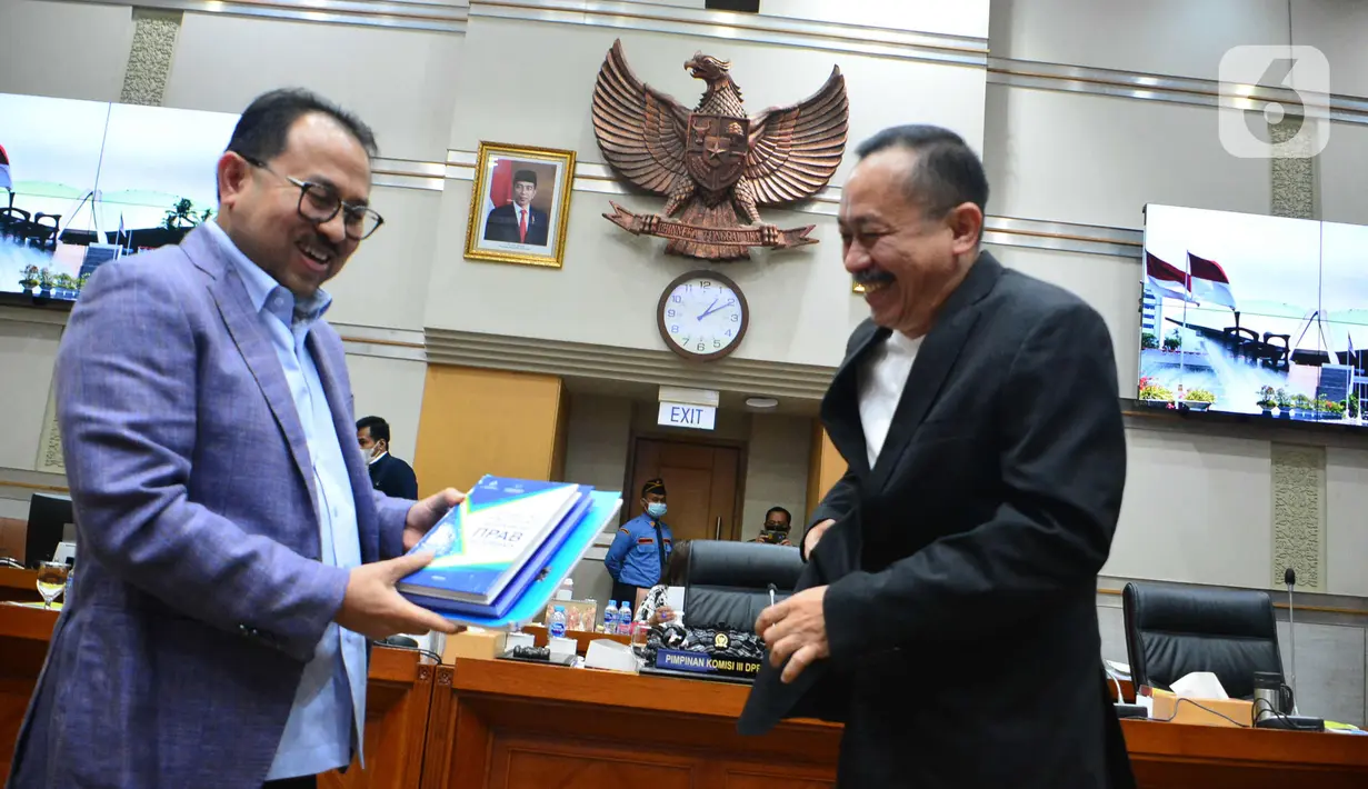 Wakil Ketua Komisi III DPR RI, Pangeran Khairul Saleh (kiri) memberikan buku kepada Ketua Komnas HAM Ahmad Taufan Damanik sebelum Rapat Dengar Pendapat dengan Komisi III di Kompleks Parlemen, Senayan, Jakarta, Selasa (6/4/2021).  (Liputan6.com/Angga Yuniar)