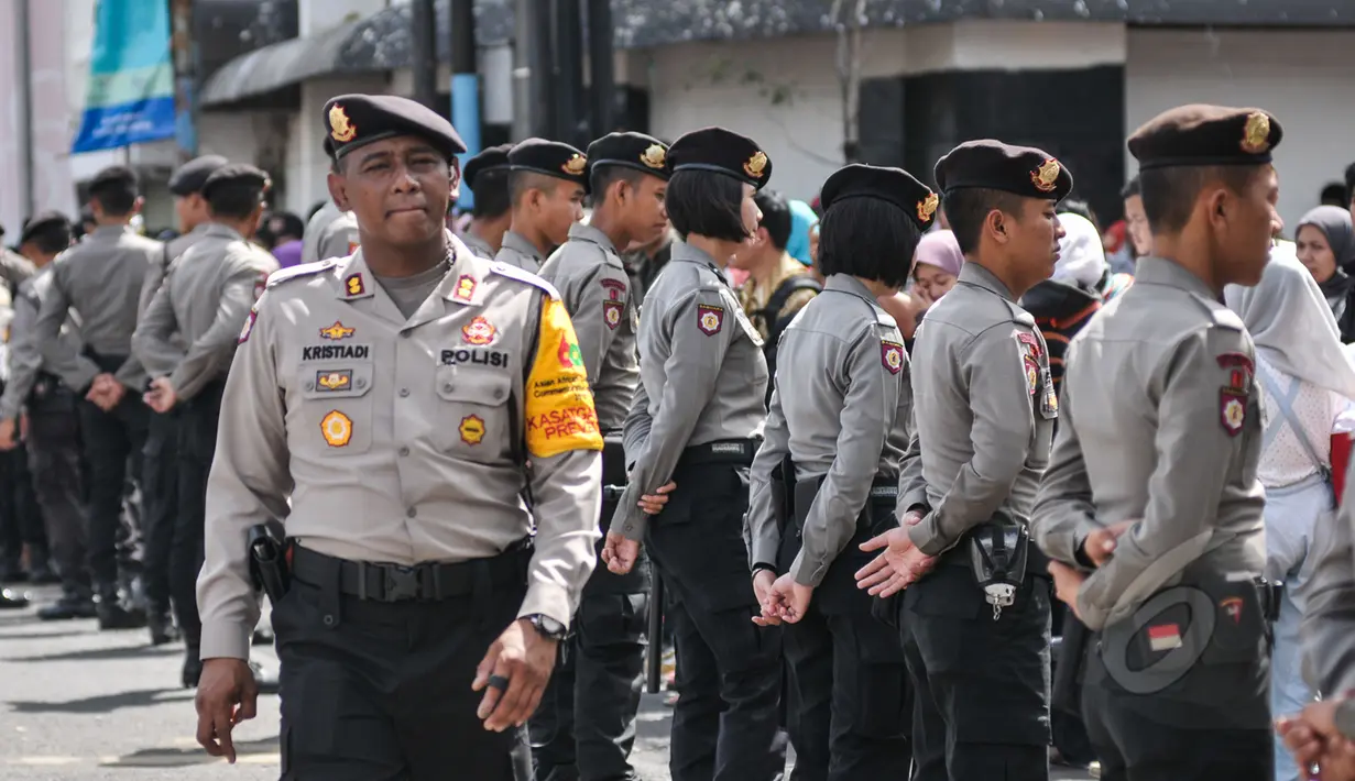 Petugas kepolisian berbaris menjaga jalan yang dilalui Para kepala Negara dan delegasi dari Asia dan Afrika mengikuti 'Historical Walk' dalam rangkaian Peringatan KAA ke-60, di Jalan Asia Afrika, Bandung, Jumat (24/4/2015). (Liputan6.com/Faizal Fanani)