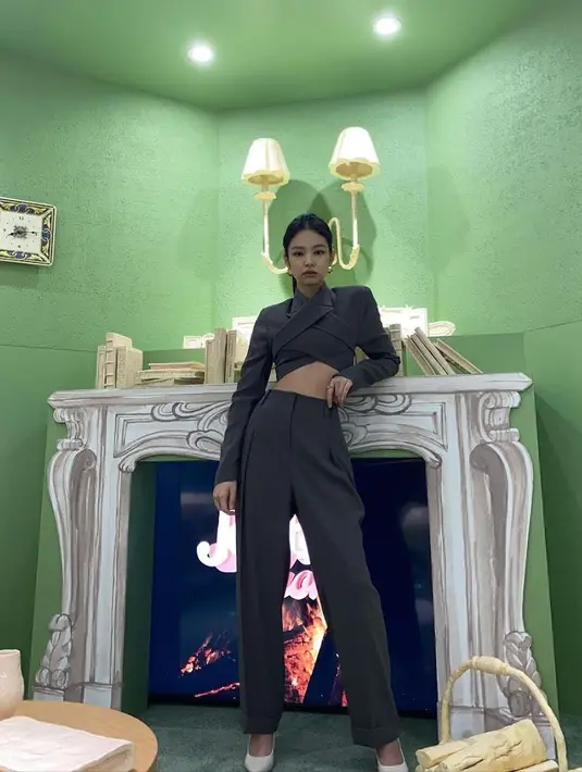 Jennie mengenakan kemeja asimetris crop top yang dipandukan dengan pants warna senada. Ia juga menggunakan heels putih, gayanya like a boss.(@jennierubyjane)