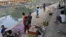 Anak-anak bermain di bantaran anak Sungai Ciliwung, Jakarta, Rabu (6/6). Meskipun tidak layak sebagai tempat bermain, namun lokasi itu menjadi tempat bagi anak-anak di kawasan tersebut untuk menunggu waktu berbuka. (Liputan6.com/Immanuel Antonius)