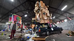 Seorang pria berdiri di dekat sebuah karya seni jalanan oleh kolektif seniman yang ditampilkan Iretge sebagai bagian dari pameran "Strokar inside" di bekas supermarket di Brussels (5/9). (AFP Photo/Emmanuel Dunand)