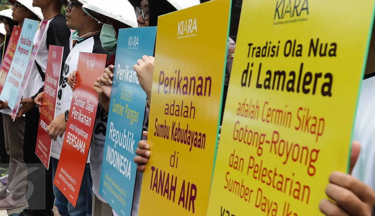Pengunjuk rasa menunjukan tulisan saat aksi di depan gedung KKP, Jakarta (21/11). Aksi ini mengajak masyarakat Indonesia untuk menjaga sumber daya kelautan dari ancaman kerusakan dan penangkapan ikan ilegal. (Liputan6.com/Faizal Fanani)