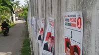 Tidak hanya di tempat-tempat terbuka, sarana ibadah dan tembok sekolah ikut ditempeli poster pasangan calon. (Edhie Prayitno Ige/Liputan6.com)