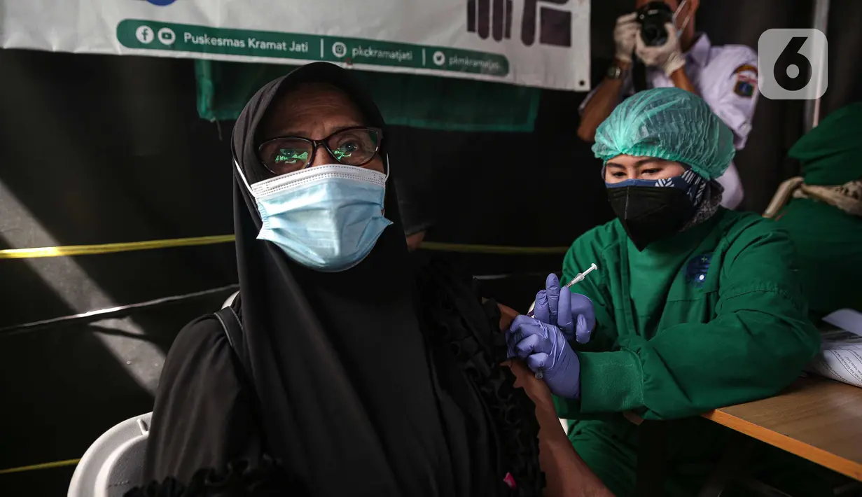 Tenaga kesehatan menyuntikkan vaksin COVID-19 dosis ketiga kepada warga di Puskesmas Kecamatan Kramat Jati, Jakarta, Rabu (12/1/2022). Program vaksinasi lanjutan (booster) COVID-19 diberikan kepada kelompok prioritas yaitu lanjut usia dan penderita immunokompromais. (Liputan6.com/Faizal Fanani)