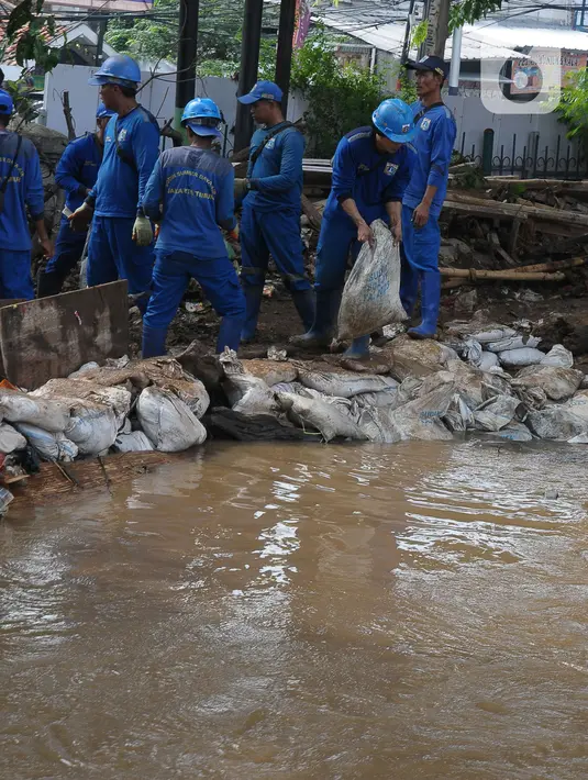 Badan Penanggulangan Bencana Daerah (BPBD) Jakarta menyebutkan penyebab tanggul kali itu jebol karena debit air yang tinggi akibat hujan deras. (merdeka.com/Imam Buhori)