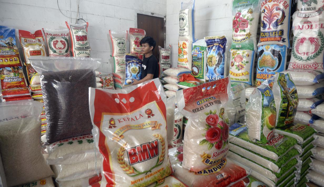 Pedagang memindahkan beras yang dijual di pinggir Jalan Raya Pamulang, Tangerang Selatan, Banten, Jumat (11/12/2020). Jelang Natal dan Tahun Baru 2021, harga beras dipasaran masih normal tidak ada kenaikan. (merdeka.com/Dwi Narwoko)