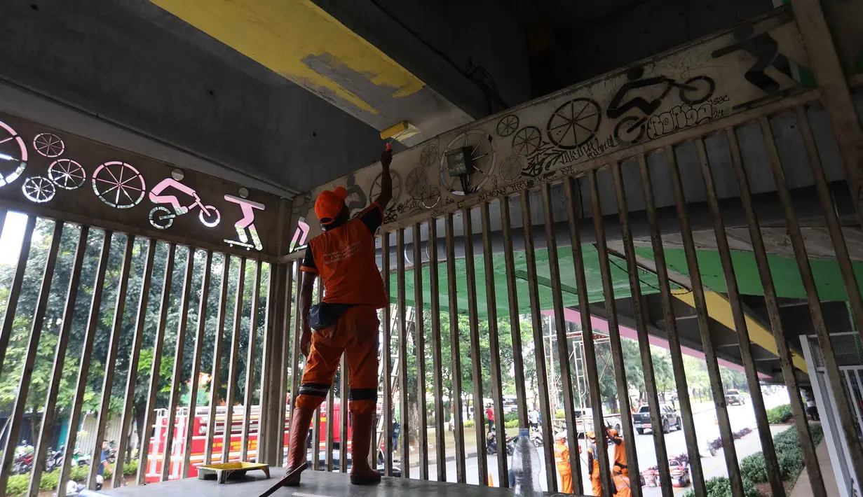 Bersama jajaran Suku Dinas Bina Marga, petugas PPSU melakukan pengecatan ulang, pembuatan mural, pembersihan debu, serta perapian tanaman di jalur hijau sekitar arena. Tampak dalam foto, salah satu petugas Penanganan Prasarana dan Sarana Umum (PPSU) melakukan pengecatan di kolong jembatan layang Pasar Rebo, Jakarta Timur, Jumat (8/5/2026). (Kapanlagi.com/Budy Santoso)