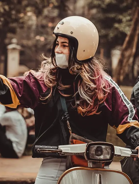 Meski kerap tampil dengan busana boyish, Sintya tetap begitu anggun saat rambutnya dibiarkan tergerai kala mengendarai vespanya. Terlebih lagi rambut panjangnya dicat dengan warna unik. (Liputan6.com/IG/@sintyamarisca)