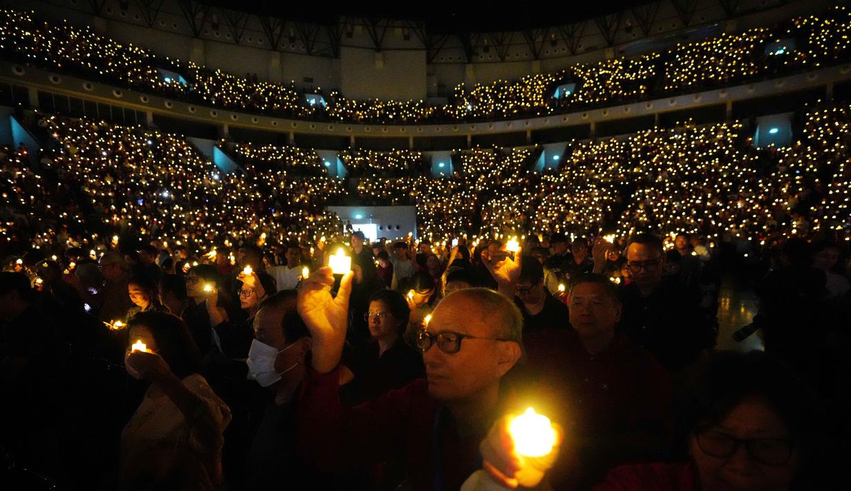 Perayaan Natal Akbar ini dipimpin oleh Pendeta Stephen Tong dengan tema ibadah "Mengapa Allah Menjadi Manusia". Tampak dalam foto, orang-orang memegang lilin elektrik selama kebaktian Malam Natal di Indonesia Arena, Kompleks Gelora Bung Karno, Jakarta, Rabu 24 Desember 2025. (AP Photo/Tatan Syuflana)
