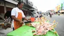 Penjual memotong daging ayam dagangannya di sebuah pasar tradisional usai gempa dan tsunami melanda Palu, Sulawesi Tengah, Kamis (4/10). Meski belum terlalu banyak yang berjualan, keberadaan pedagang sangat membantu masyarakat. (Permata SAMAD/AFP)