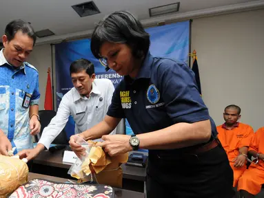 Deputi Pemberantasan BNN, Arman Depari (kiri) memeriksa barang bukti sabu saat rilis di Jakarta, Selasa (24/5/2016). BNN kembali mengungkap dua kasus penyelundupan narkoba jenis sabudengan tujuh orang tersangka. (Liputan6.com/Helmi Fithriansyah)