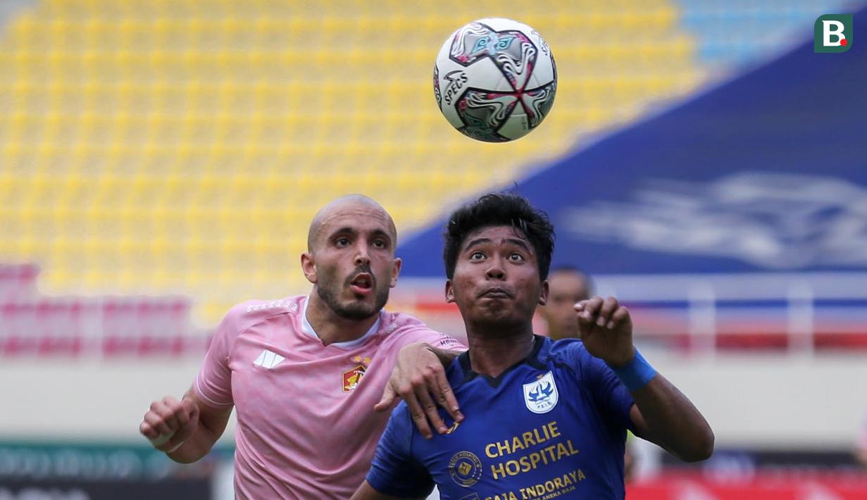 Pemain Persik Kediri, Youssef Ezzejjari Lhasnaoui (kiri) dan pemain PSIS Semarang, M Rio Saputro berebut bola diudara saat laga pekan ketujuh BRI Liga 1 2021/2022 antara PSIS Semarang melawan Persik Kediri di Stadion Manahan, Solo, Jumat (15/10/2021). (Bola.com/Bagaskara Lazuardi)