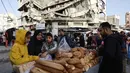 Warga Palestina menjual roti di dekat bangunan yang hancur di pasar Zawiya, Kota Gaza, pada Rabu 18 Februari 2026. Menyambut bulan suci Ramadan 1447 Hijriah, warga Palestina di Kota Gaza memadati Pasar Al-Zawiya. (Omar AL-QATTAA/AFP)