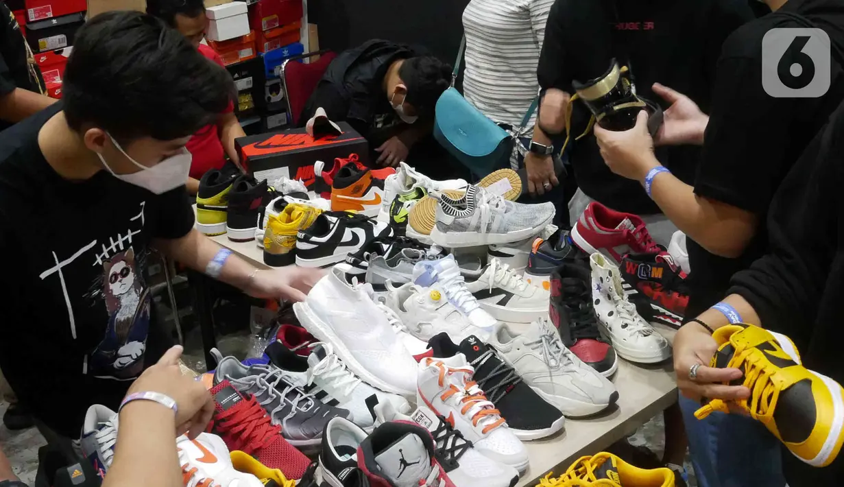 Pengunjung memilih produk yang ditawarkan di Urban Sneaker Society 2021 di JCC, Senayan, Jakarta, Minggu (5/12/2021). Acara menghadirkan kegiatan NFT Gallery, Sneaker Museum dan juga Raffle yang menjadi salah satu daya tarik Urban Sneaker Society dari tahun ke tahun. (Liputan6.com/Herman Zakharia)