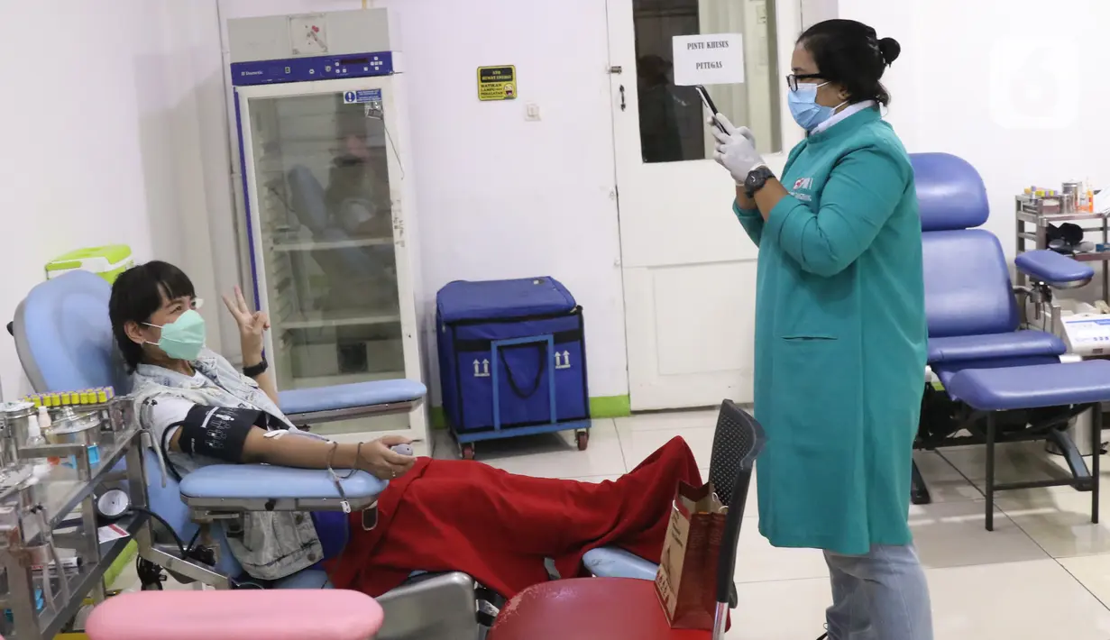 Warga berpose untuk foto saat donor darah di PMI Kota Tangerang, Sabtu (12/3/2022). Stok darah di PMI kota Tangerang menjelang bulan puasa atau Ramadhan masih aman dalam beberapa hari ke depan. (Liputan6.com/Angga Yuniar)