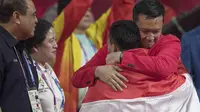 Menpora RI, Imam Nahrawi, memeluk lifter Indonesia, Eko Yuli Irawan, usai berlaga pada Asian Games di JIExpo, Jakarta, Selasa, (21/8/2018). Eko Yuli berhasil menyumbang medali emas angkat besi putra kelas 62kg. (Bola.com/Peksi Cahyo)