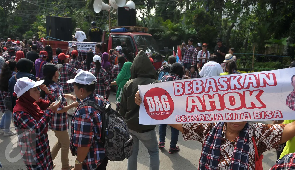 Seorang pendukung Ahok membentangkan spanduk saat mengawal sidang di Kementerian Pertanian, Jakarta, Selasa (25/4). Dalam Sidang yang beragendakan pembacaan pledoi peserta tetap setia dan semangat sambil berjoget.(Liputan6.com/Helmi Afandi)