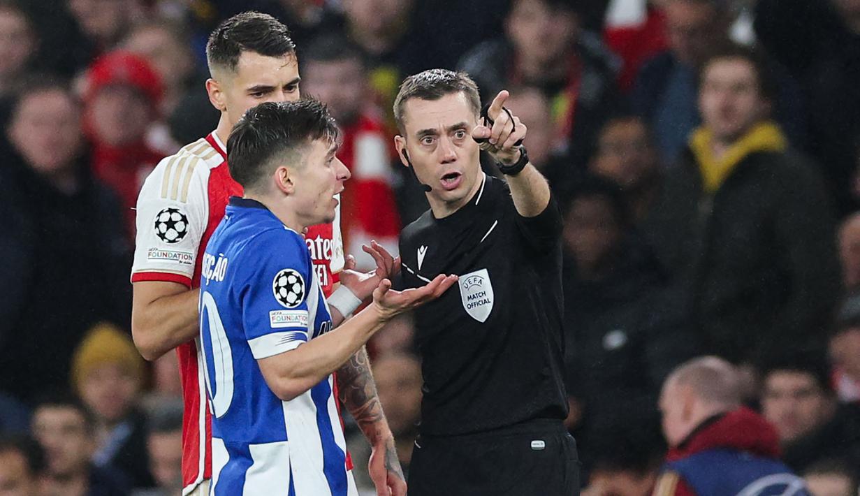 Wasit Clement Turpin (kanan) saat mengambil keputusan pada laga leg kedua 16 besar Liga Champions 2023/2024 antara Arsenal Melawan Porto di Emirates Stadium, London, Inggris, Rabu (13/03/2024) dini hari WIB. (AFP/Adrian Dennis)