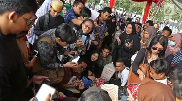 Sejumlah warga memadati pusara mendiang Presiden ketiga BJ Habibie di Taman Makam Pahlawan Nasional Kalibata, Jakarta, Kamis (12/9/2019). Mereka mengantre untuk berfoto maupun berdoa di depan makam BJ Habibie. (Liputan6.com/Herman Zakharia)
