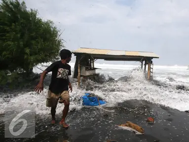 Warga  menghindari terjangan gelombang pasang di Pantai Depok,Yogyakarta,Kamis (9/6). Fenomena gelombang tinggi melanda pesisir pantai selatan Indonesia dalam beberapa hari ini. (Liputan6.com/Boy Harjanto)