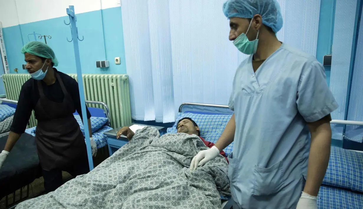 Dokter mengecek kondisi pria korban serangan bom bunuh diri di rumah sakit Wazir Akbar Khan di Kabul, Afghanistan (31/10). Dilaporkan sedikitnya 4 Orang tewas dan puluhan lainnya luka-luka akibat serangan tersebut. (AP Photo/Massoud Hossaini)