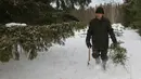 Mikhail Baburin (66) memotong pohon untuk dijadikan Pohon Natal di desa Mikhailovka, Siberia, 5 Desember 2016. Baburin adalah penduduk terakhir Desa Mikhailovka, yang didirikan oleh migran dari Mordovia, Rusia, pada abad ke-19. (REUTERS/Ilya Naymushin)